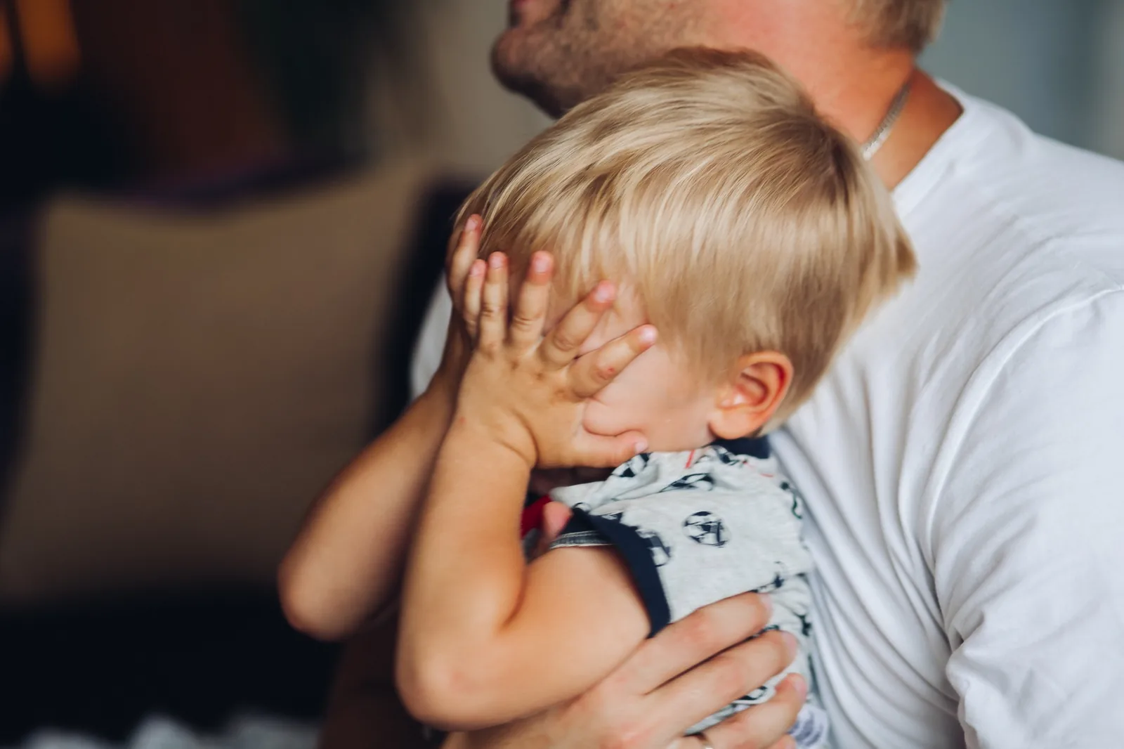 niño llorando en brazos de su padre durante una fase de mamitis aguda y ansiedad por separación