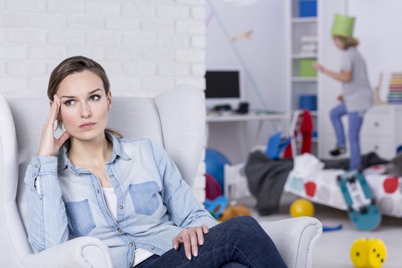 Madre agotada sentada en un sillón