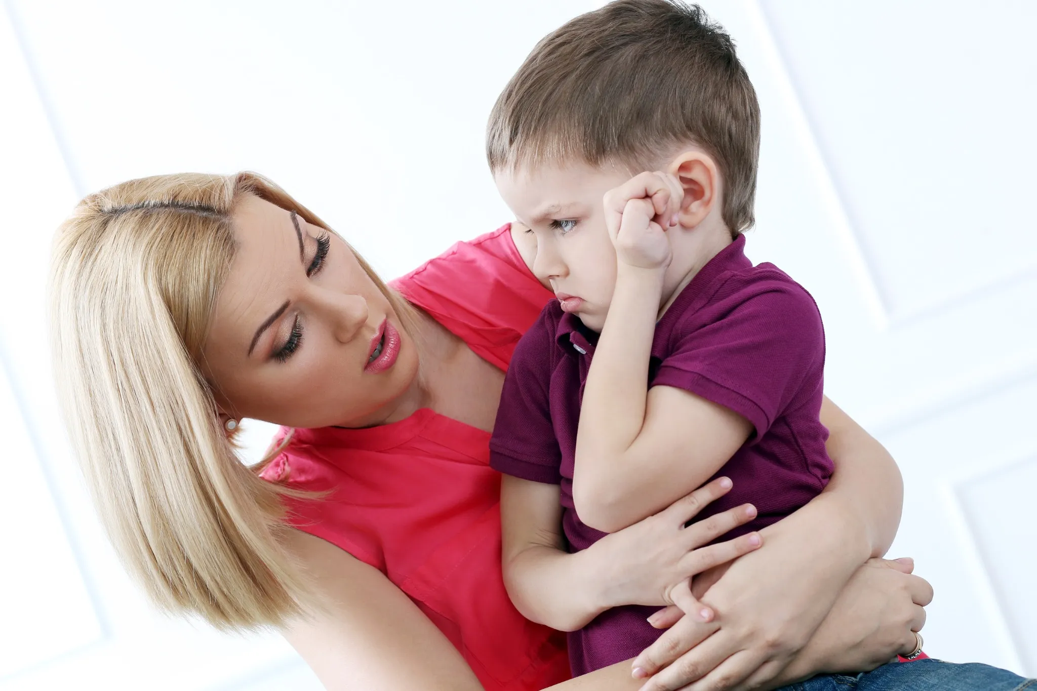 Cómo ayudar a los niños a gestionar emociones: madre abrazando y consolando a su hijo en un momento de enfado, destacando la importancia de la educación emocional en casa.