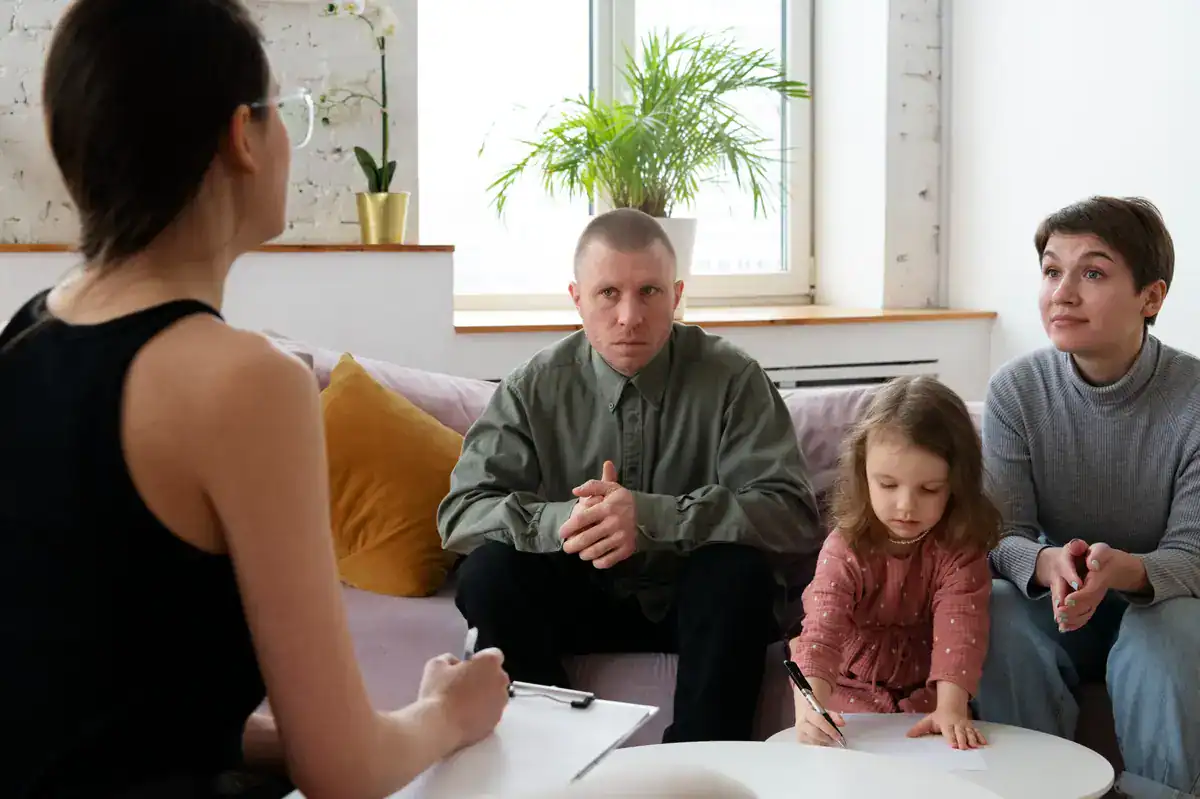 Psicóloga atendiendo a una familia con su hija en una sesión de orientación