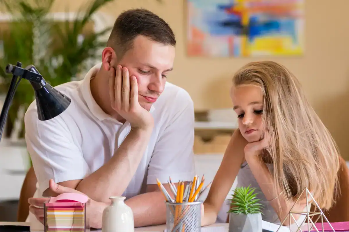 La preocupación parental aparece en lo cotidiano. Padre acompañando a su hija mientras hacen deberes en casa