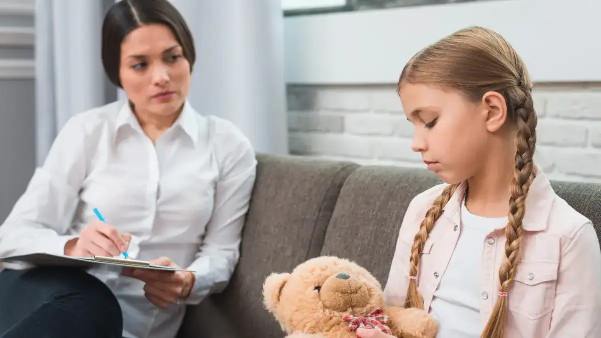 Psicóloga conversando con una niña en un entorno terapéutico