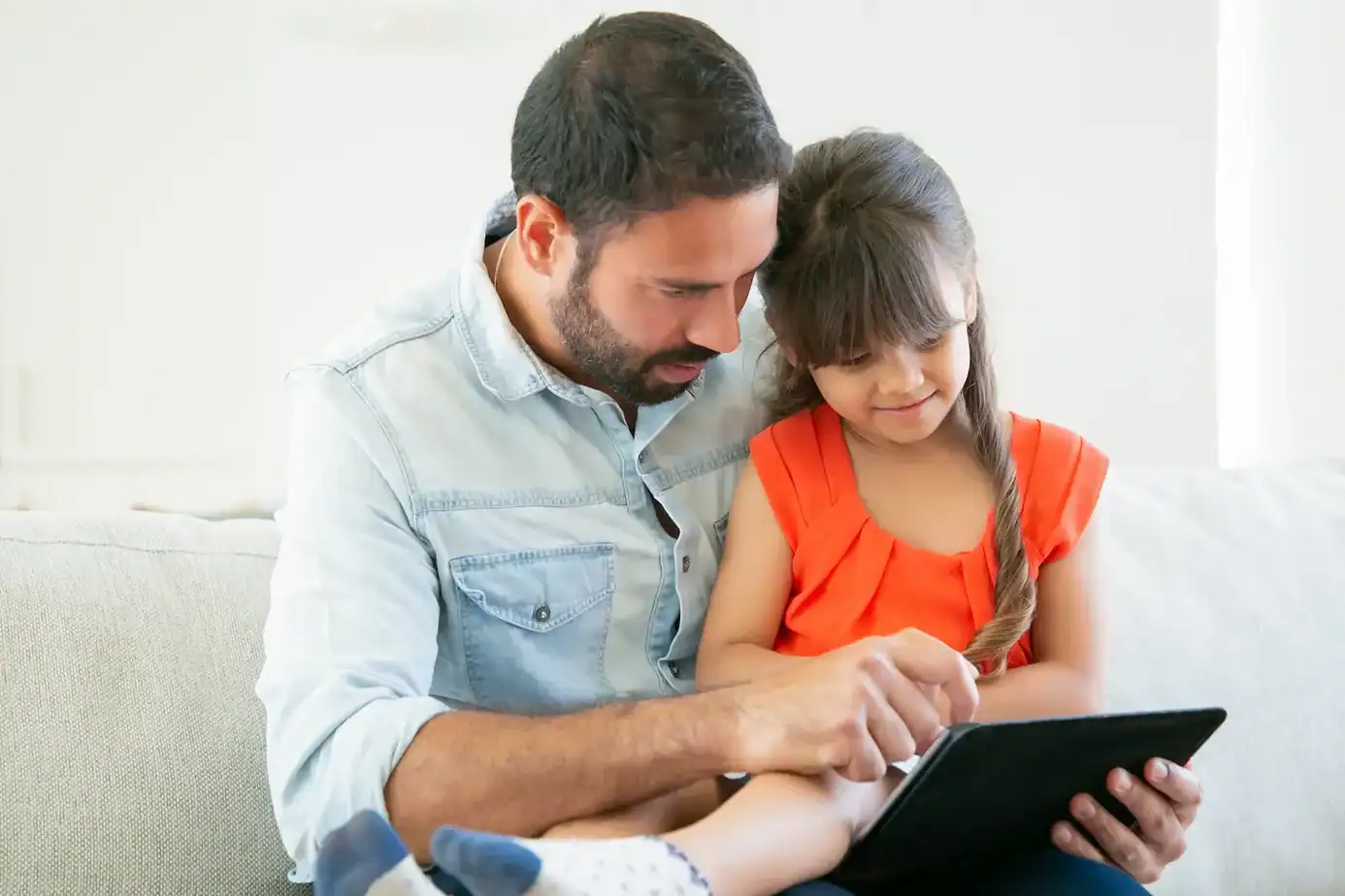 niños y pantallas: padre acompañando a su hijo mientras usa una tablet