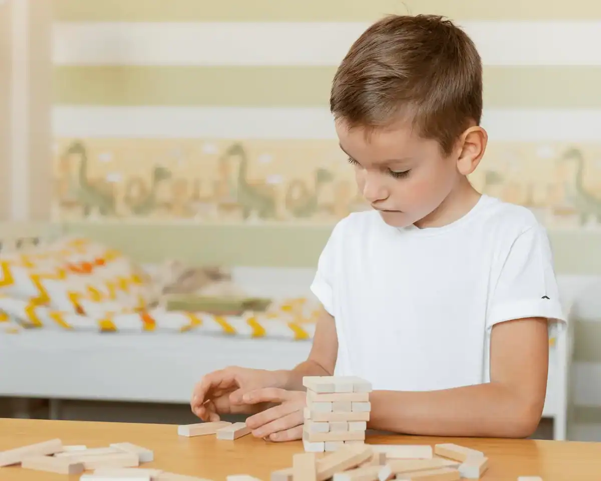 niño de 5 años jugando con piezas de madera desarrollando la concentración