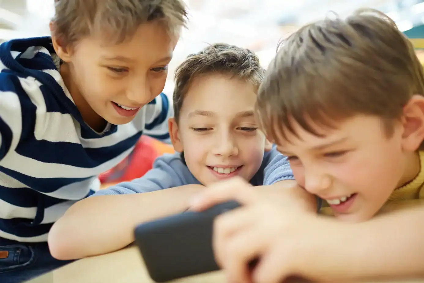 Niños mirando juntos un smartphone viendo contenido digital