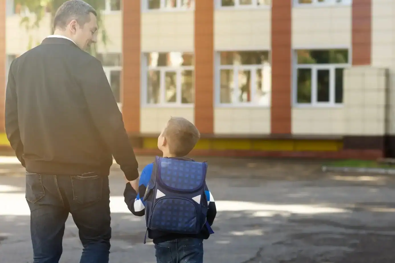 Padre acompañando a su hijo al colegio en el inicio del curso escolar